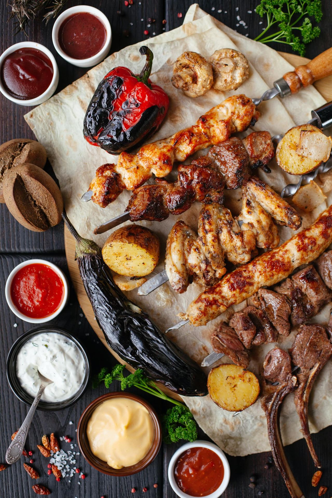 Grillbuffet mit Fleisch, Spießen, Dips und Beilagen